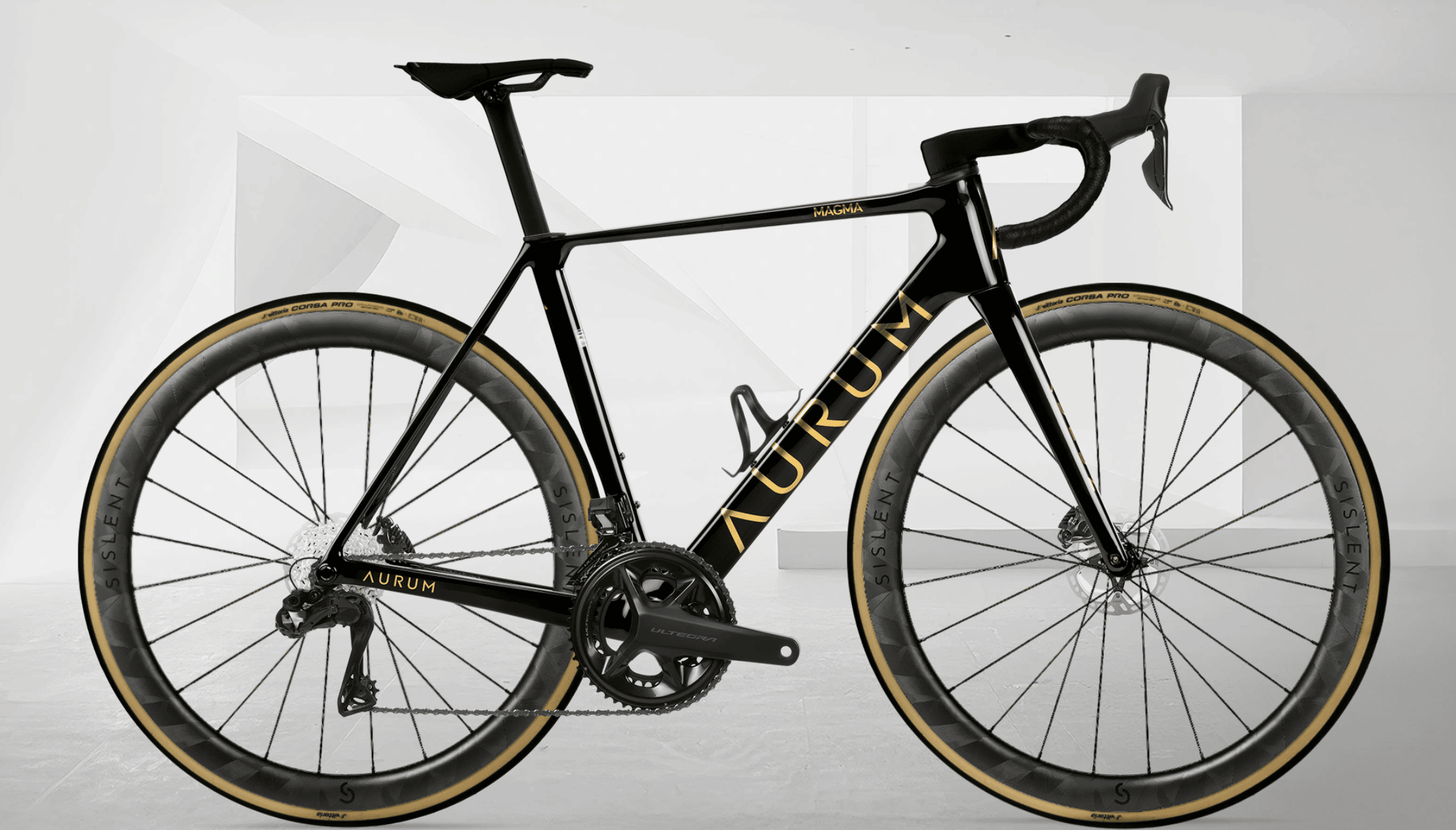 Sort AURUM Magma landeveissykkel med gullfargede detaljer, fotografert fra siden mot en lys, geometrisk hvit bakgrunn.
